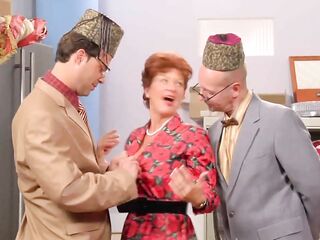 Red haired older in a floral suit is about to have a male+male+female three-some at work